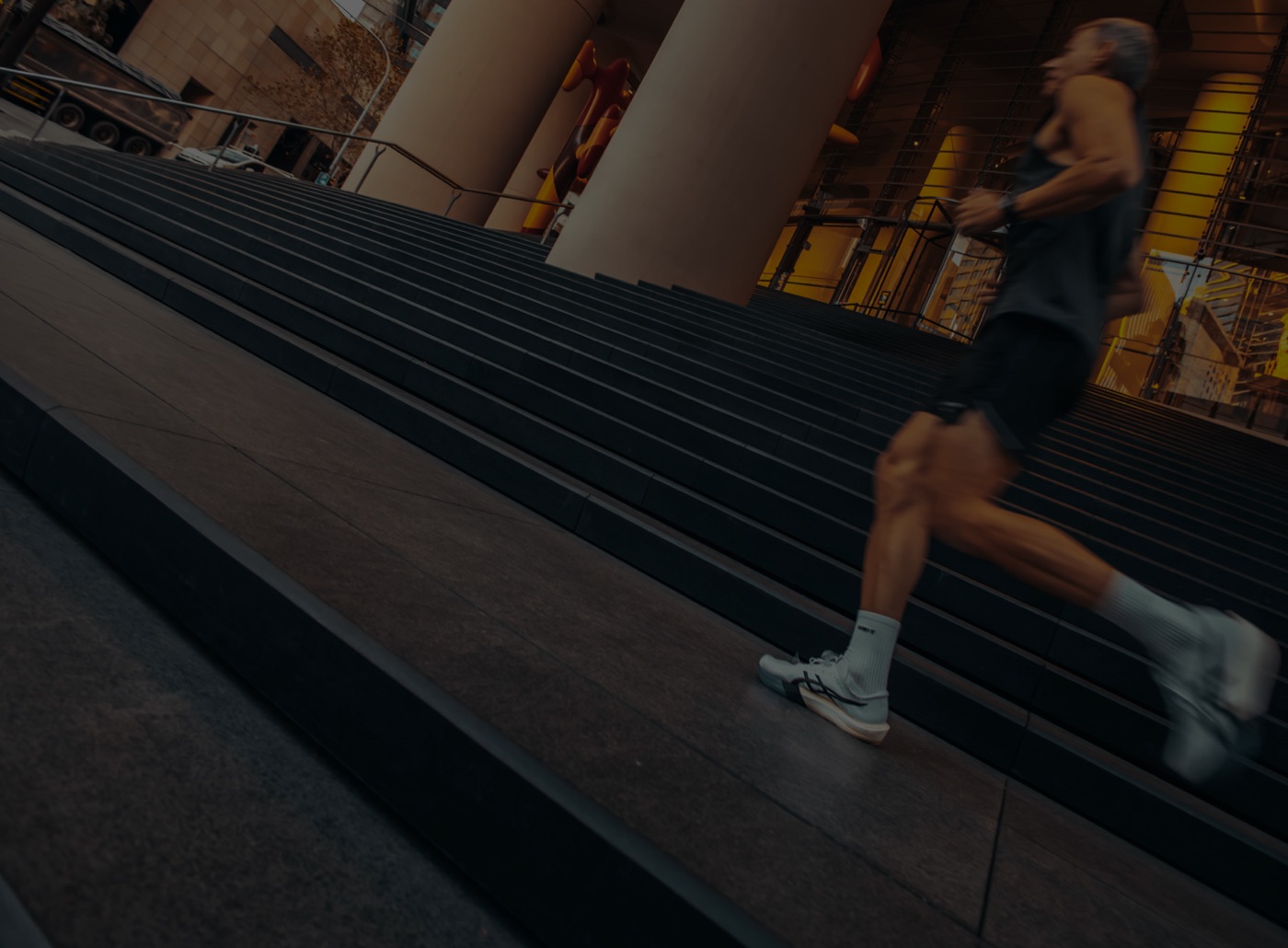 A runner climbing city steps at dusk